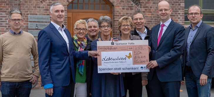 Scheckübergabe vor dem Fuldaer Malteser-Zentrum in der früheren EIKA-Kerzenfabrik (von links): Wilfried Wanjek, Leiter Malteser Hospiz-Zentrum; Ralph Burkhardt, Vorstandsvorsitzender der R+S Group AG; Elfi Makowka; Palliativmediziner Dr. Peter Fehrenbach; Silvia Hillenbrand, Stv. Vereinsvorsitzende; Dagmar Pfeffermann, Leitung Hospiz St. Elisabeth; Palliativstiftung Dr. Thomas Sitte; Michael Brand, Vorsitzender Hospiz-Förderverein Fulda; Schatzmeister Volker Hans.